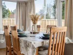 a dining room with a table and chairs and a window at Maryland Cottage in Aberargie