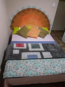 a bed with a headboard and pillows on it at Pousada Refúgio da Chapada in Cavalcante