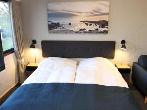 a bedroom with a large bed with two lamps on two tables at 2 person holiday home in Allinge in Allinge