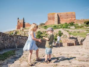 een klein meisje en een jongen die naast een kasteel staan bij 2 person holiday home in Allinge in Allinge