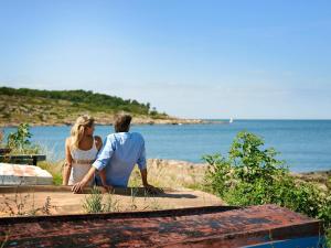 um homem e uma mulher sentados numa mesa a olhar para o oceano em 2 person holiday home in Allinge em Allinge