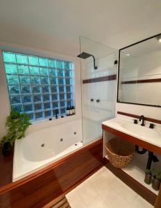 a bathroom with a tub and a sink and a shower at Wabi Sabi Avoca in Avoca Beach