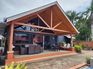 een paviljoen met tafels en stoelen op een patio bij Homestay Umbai Kelana in Merlimau