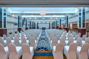 an empty hall with white chairs and a projection screen at InterContinental Muscat by IHG in Muscat +37 photos