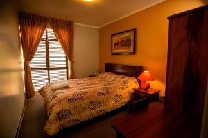 a bedroom with a bed and a window and a lamp at Hotel Rivera in Ayacucho