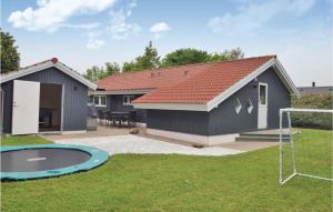 una casa con un aro de baloncesto en un patio en Stunning Home In Juelsminde With Sauna en Sønderby