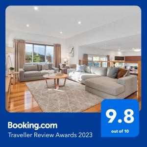 a living room with two couches and a table at Seaford Luxe Beach House 2023 BDC Traveller award winner in Seaford