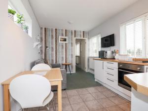 a kitchen and living room with a table and chairs at Endless Summer in Newquay