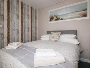 una camera da letto con un letto bianco e asciugamani di Endless Summer a Newquay