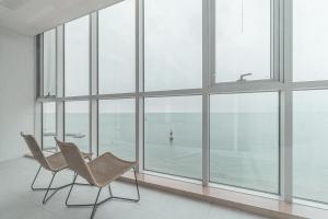 two chairs in a room with large windows at Pale De Cz Condo in Busan