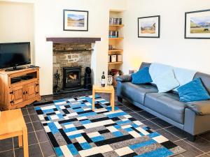 a living room with a couch and a fireplace at Isallt in Nantlle