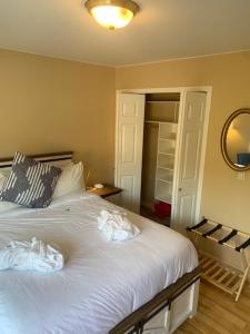 a bedroom with a bed with white sheets and a mirror at Salish B&B and Spa in West Kelowna
