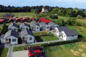 a group of houses with cars parked in a parking lot at One-storey holiday houses near the beach, G ski in Gąski