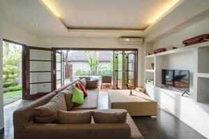 a living room with a couch and a tv at Nunia Boutique Villa in Seminyak