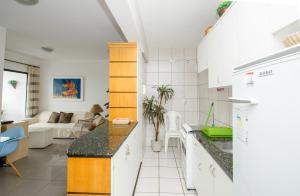 a kitchen with a counter and a living room at Meireles Ana Bilhar in Fortaleza