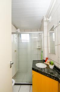 a bathroom with a glass shower and a sink at Meireles Ana Bilhar in Fortaleza