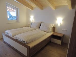 a bedroom with a bed with two lights on at Z`Aglers Ferienwohnungen in Oberau