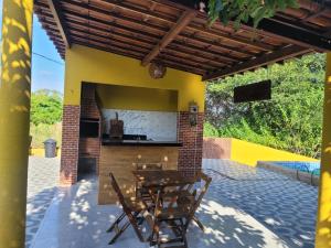 a patio with a table and chairs and a kitchen at Rancho Santa Helena in Juazeiro