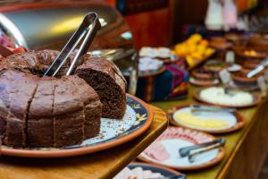 a chocolate cake on a table with tongs in it at Hotel Pakaritampu in Ollantaytambo