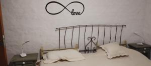 een slaapkamer met een bed en een bord met liefde bij La Rosadita del Paraje in Villa Yacanto