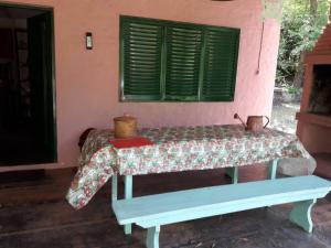 Cama en habitación con ventana y mesa en La Rosadita del Paraje en Villa Yacanto