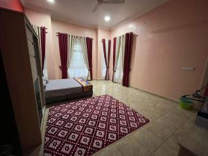 a bedroom with a bed and a red rug on the floor at D'Rhu Homestay with 2 aircond in Bachok