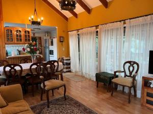 - un salon avec une table à manger et des chaises dans l'établissement Acogedora casa en Pingueral, à Concepción