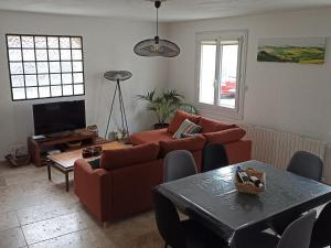 ein Wohnzimmer mit einem Sofa und einem Tisch in der Unterkunft Gîte Bergerac, 4 pièces, 6 personnes - FR-1-616-271 in Bergerac