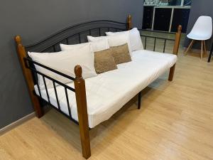 a bed with white sheets and pillows on it at Stylishly Spacious in Tanjung Bungah