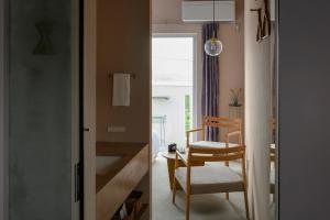 MEGURU l 巡 في جزيرة إيشيغاكي: غرفة بها كرسي وطاولة ونافذة