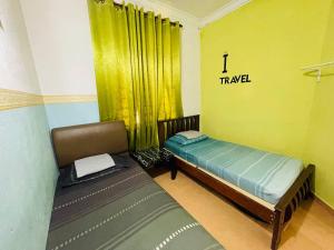 a bedroom with two beds in a room with yellow walls at Niks Homestay Kok Lanas in Kampong Kok Lanas