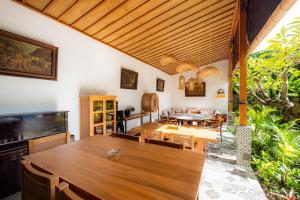 a dining room with a large wooden table and chairs at Kubu Kirana by Supala in Ubud
