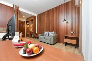 BanjarnegaraにあるFOX HARRIS Hotel & Convention Banjarnegaraのテーブルとフルーツの盛り合わせが備わる部屋