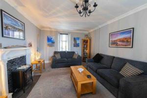 a living room with a couch and a fireplace at Hill Crest - cliff top cottage with stunning views in Cullen