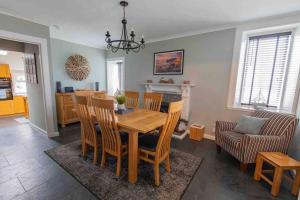 uma sala de jantar e sala de estar com mesa e cadeiras em Hill Crest - cliff top cottage with stunning views em Cullen