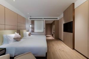 Postel nebo postele na pokoji v ubytování Kew Green Hotel Hongqiao Shanghai