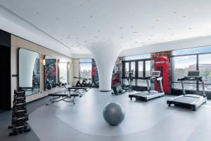 un gimnasio con un montón de equipos de ejercicio y una cabina de teléfono rojo en Kew Green Hotel Hongqiao Shanghai, en Shanghái