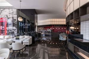 Kew Green Hotel Hongqiao Shanghai في شانغهاي: مطعم بطاولات بيضاء وكراسي وبار