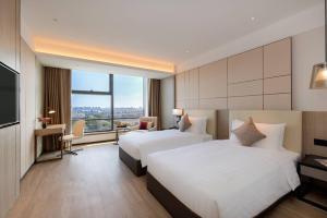 Postel nebo postele na pokoji v ubytování Kew Green Hotel Hongqiao Shanghai