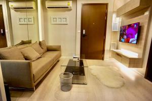 ein Wohnzimmer mit einem Sofa und einem Glastisch in der Unterkunft Luxury Apartment near Downtown (Pick-up Service) in Bangkok