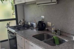 encimera de cocina con fregadero y fogones en Luminoso monoambiente con pileta y gym Villa Crespo Movistar Arena en Buenos Aires