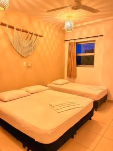 1 Schlafzimmer mit 2 Betten und einem Fenster in der Unterkunft Awa De Mar Hotel in Tolú