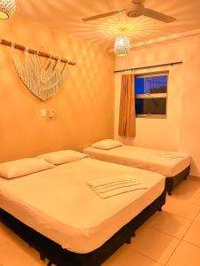 a bedroom with two beds and a window at Awa De Mar Hotel in Tolú