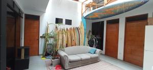 Habitación con silla y tablas de surf en la pared. en Bravo Hostels: Surf House, en Punta Hermosa