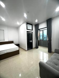 een slaapkamer met een bed en een bank erin bij Era Apartment Tran Thai Tong in Hanoi