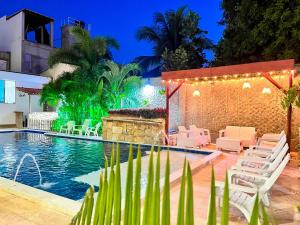 einen Pool in der Nacht mit Stühlen und einem Tisch in der Unterkunft Awa De Mar Hotel in Tolú