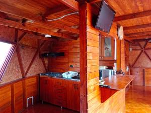 a kitchen with wooden walls and a tv on the wall at Glamping San Sebastian in Suesca