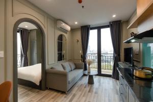 sala de estar con sofá, cama y cocina en Mercury Beach DaNang, en Da Nang
