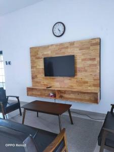 a living room with a tv on a wall at The Second Homestay in Port Dickson