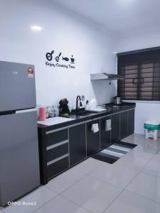 a kitchen with a sink and a refrigerator at The Second Homestay in Port Dickson